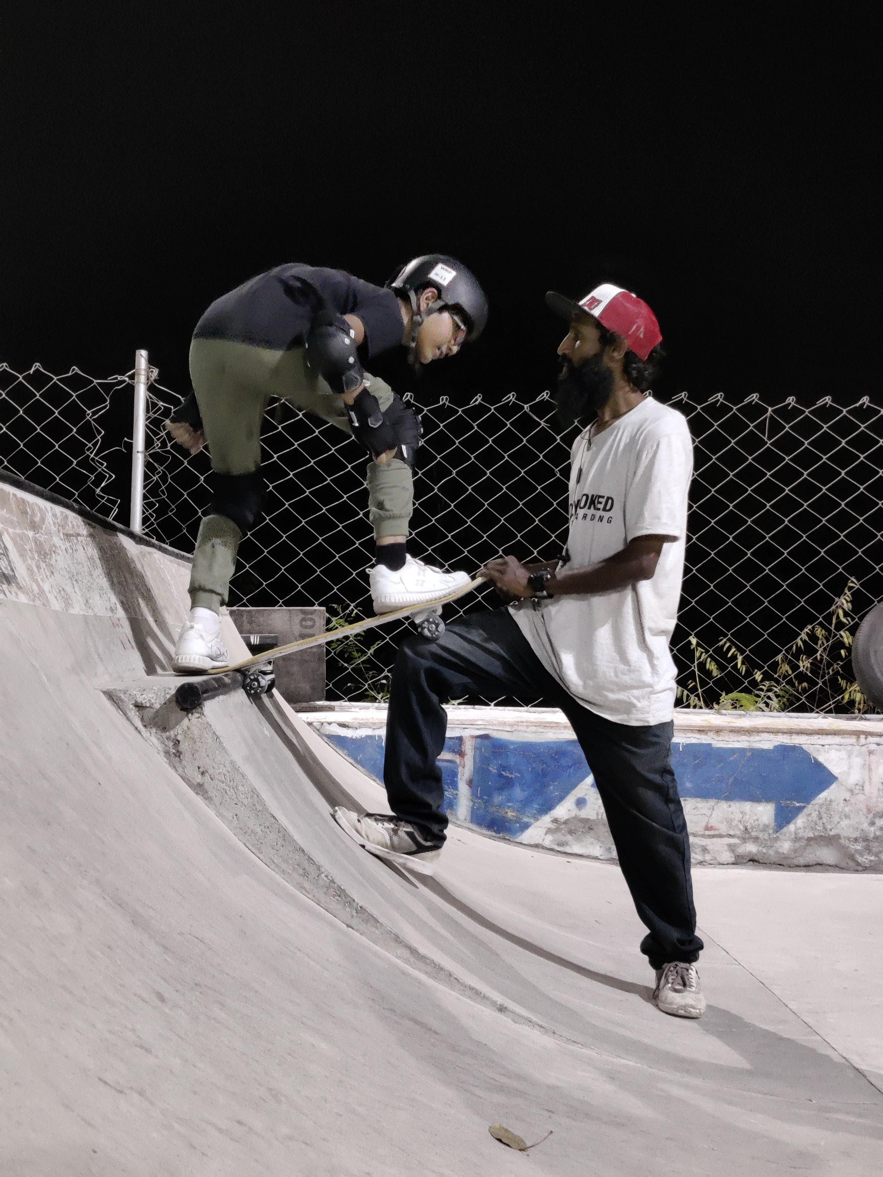 Coach helping a young skateboarder at WallRide Park